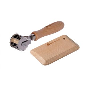 May include: A pasta-making set featuring a ravioli cutter with a wooden handle and a small wooden board. The cutter has a fluted, circular blade and a metal frame. The board is rectangular with rounded edges and the text "agliapasto.com".
