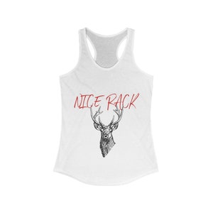 Puede incluir: Camiseta blanca de tirantes con una ilustración en blanco y negro de una cabeza de ciervo con cuernos. El texto "NICE RACK" está escrito en rojo sobre el ciervo.