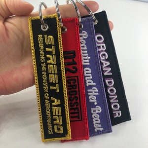 Custom jet tags keychain, keychains for clothing,Custom high quality embroidered name keychain, wholesale keychains, woven keychains