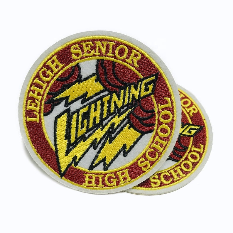 May include: Two red, white, and gold embroidered patches with the text "Leigh Senior High School" and a lightning bolt graphic. The text "Lightning" is written in a stylized font.