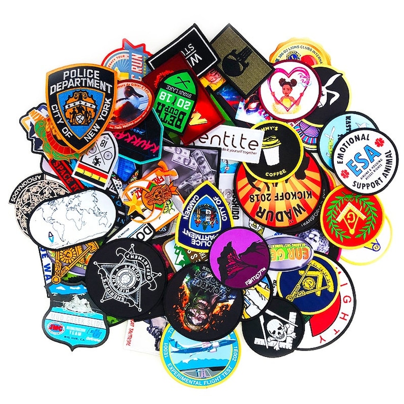 May include: A collection of colorful iron-on patches featuring various designs, including a police department patch, a city of Camden patch, a kick-off 2018 patch, a zombie patch, and a patch with the text "ESA Support Animal".