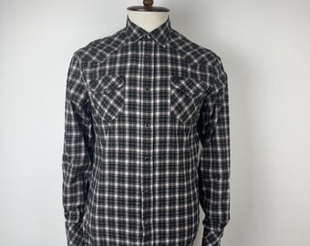 May include: A black and white plaid long-sleeve shirt with a button-down collar and two chest pockets.