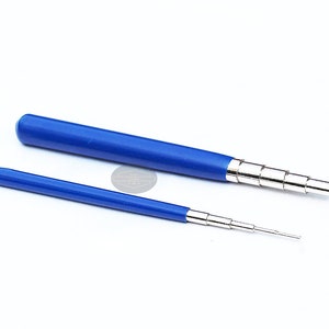 Puede incluir: Dos herramientas azules y plateadas, una grande y otra pequeña, se muestran sobre un fondo blanco. Las herramientas tienen mangos azules y puntas telescópicas plateadas. La herramienta más pequeña mide unos 10 cm de largo.