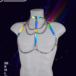 Genderless holographic harness displayed on a male mannequin with reflective rainbow tones and adjustable straps.