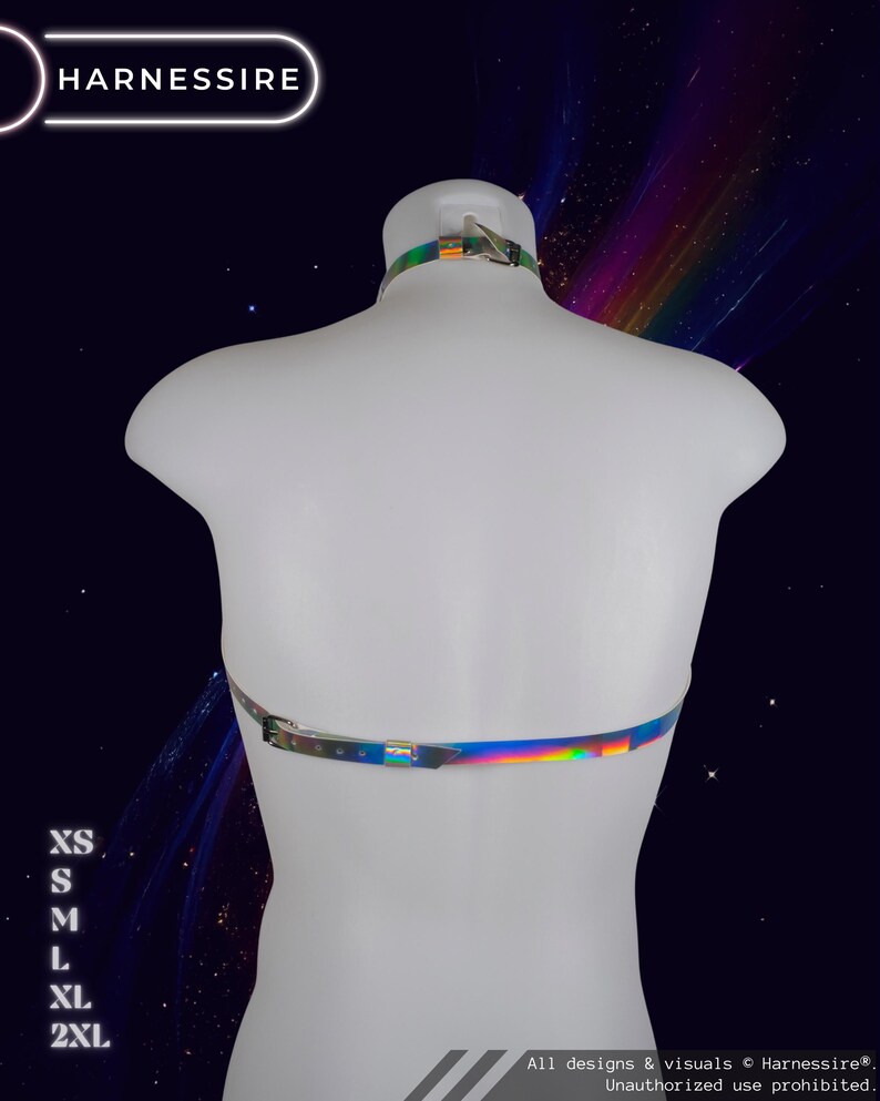 May include: A holographic harness displayed on a white mannequin. The harness has a reflective, iridescent finish with silver-tone hardware. The brand name "HARNESSIRE" is visible in the top left corner. Sizes XS to 2XL are listed on the left side.