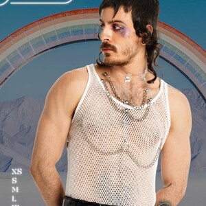 May include: White mesh tank top with silver chain detailing. The image features a person with a rainbow in the background. The brand name "HARNESSIRE" is visible at the top. Sizes XS to 2XL are listed on the left side.