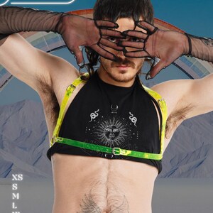 May include: A black halter top with a sun graphic and a neon green harness. The image includes the text "HARNESSIRE" in a white oval. The model is wearing black sheer gloves.