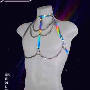 Genderless holographic harness displayed on a male mannequin with reflective rainbow tones and adjustable straps.