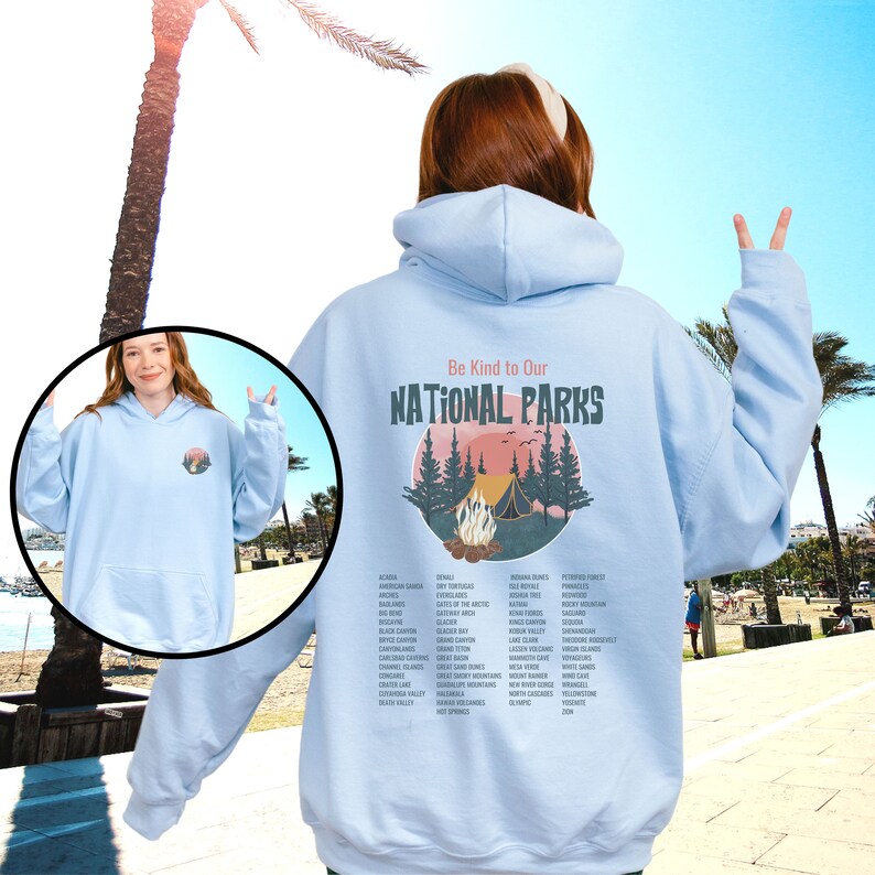 May include: Light blue hooded sweatshirt with a graphic print of a campfire scene in a forest with the text "Be Kind to Our NATIONAL PARKS" and a list of all the national parks in the United States.