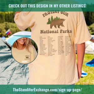May include: A beige t-shirt with a brown bear graphic and the text "Protect Our National Parks". The shirt lists the names of many national parks in the United States.