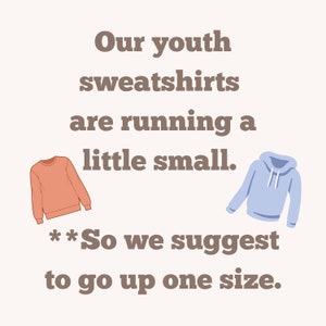 May include: Text graphic that reads "Our youth sweatshirts are running a little small. **So we suggest to go up one size."  Two illustrations of sweatshirts, one in coral and one in light blue.