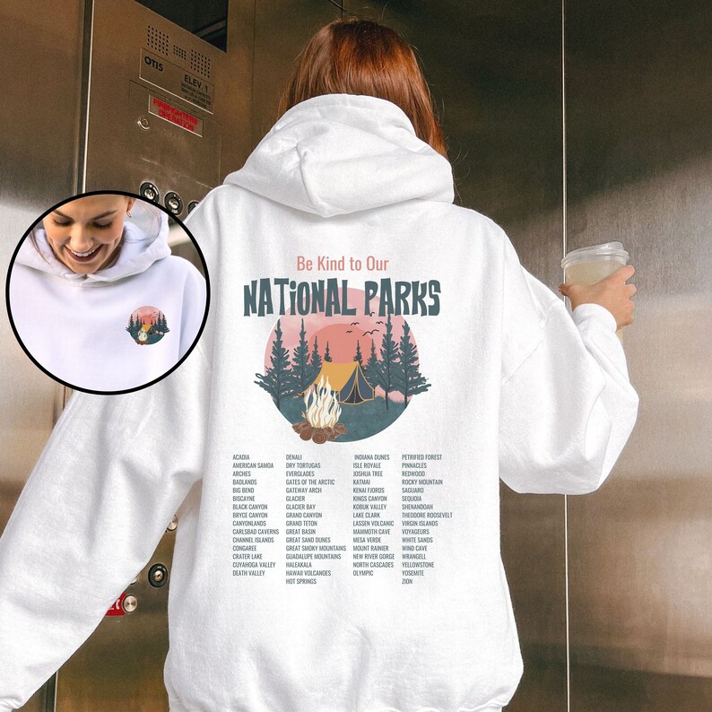 May include: White hooded sweatshirt with a graphic of a campfire in a forest with the text "Be Kind to Our National Parks" and a list of national parks printed on the back.