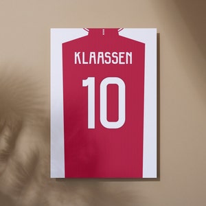 Könnte beinhalten: Ein rot-weißes Fußballtrikot mit dem Namen "KLASSEN" und der Nummer "10" auf der Rückseite.