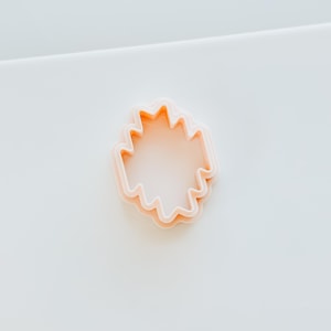 Puede incluir: Un cortador de galletas de plástico rosa en forma de estrella con múltiples puntas.