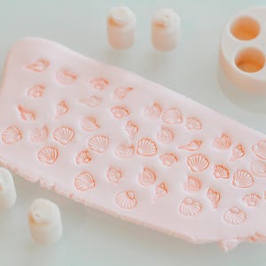 Puede incluir: Un juego de tres tazas de cerámica con un acabado moteado y mate. Las tazas son de color crema, gris claro y gris oscuro. Cada taza tiene un diseño simple y minimalista.