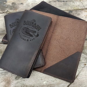 May include: Three brown leather menu covers with the text "The Bourbon Street Creole Kitchen & Bar" embossed on the front.
