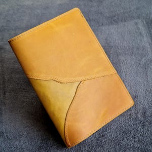 Puede incluir: Un diario de cuero marrón con un diseño único cosido. La cubierta está hecha de cuero suave y flexible, con un aspecto natural y rústico.