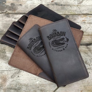 May include: Three brown leather menu covers with the text "The Bourbon Street Creole Kitchen & Bar" embossed on the front.