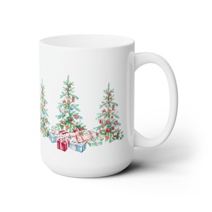 Op de afbeelding: Witte keramische mok met een kerstboomontwerp. De bomen zijn versierd met ornamenten en omringd door ingepakte cadeaus.