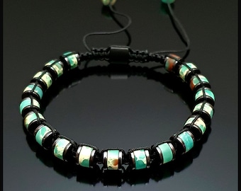 May include: A black cord bracelet with green and white patterned beads. The bracelet has adjustable cord ends with small green beads.