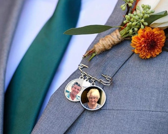 May include: A gray suit jacket with a green tie, a boutonniere with orange flowers, and a silver chain with two round photo charms.