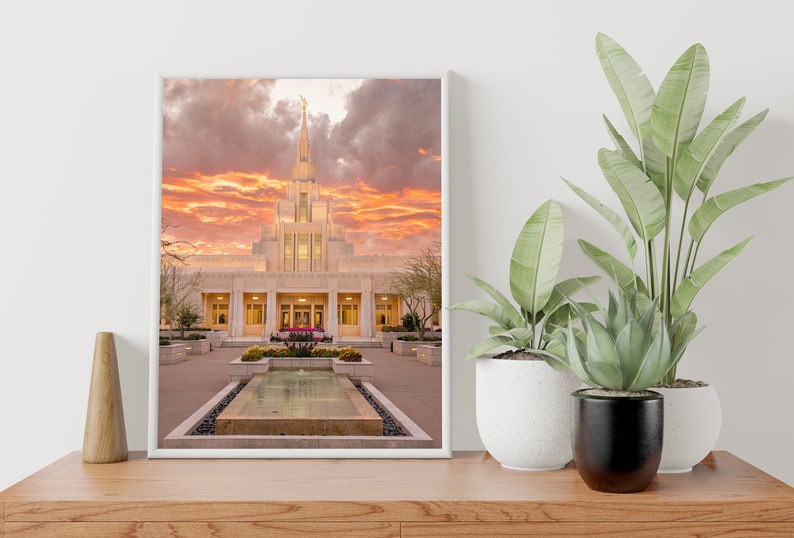 Puede incluir: Un templo blanco con una alta aguja contra un cielo de puesta de sol dram&aacute;tico. El templo est&aacute; rodeado por un patio con una piscina reflectante y paisajismo.