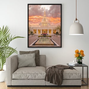 Puede incluir: Una fotograf&iacute;a enmarcada de un edificio blanco con una aguja, rodeado de un patio con una fuente. El cielo es de un naranja y rosa vibrantes, lo que sugiere una puesta de sol.