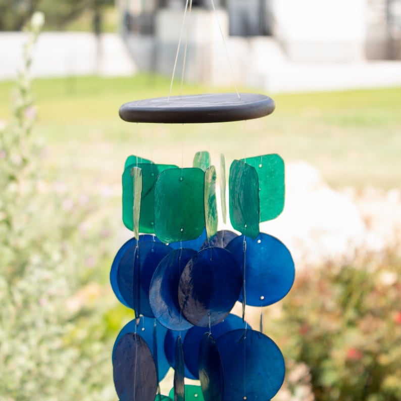 Handcrafted Wind Chime Capiz Shell Creation Coastal Design Mobile Blue Green Color Scheme Peacock Inspired Pattern Garden Decoration Patio Accent Piece Outdoor Enhancement Musical Sound Element Sunlight Reflecting Mobile Beachy Home