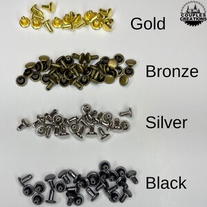 May include: Four piles of metal rivets in different colors: gold, bronze, silver, and black. The rivets are small and have a round head with a pointed shaft.
