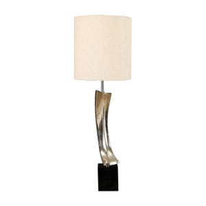 May include: A modern table lamp with a cream-colored lampshade and a curved, silver-toned metal base. The base is supported by a black square block. The lamp is designed for indoor use.