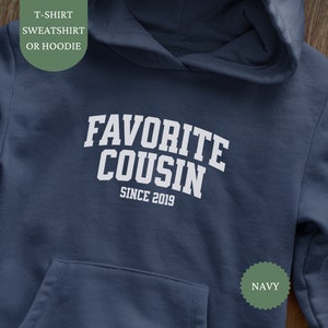 Puede incluir: Sudadera con capucha azul marino con texto blanco que dice "Primo favorito desde 2019".