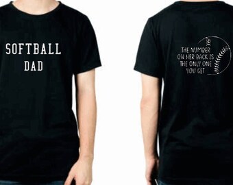 May include: Black t-shirt with the text "SOFTBALL DAD" on the front and the text "THE NUMBER ON HER BACK IS THE ONLY ONE YOU GET" with a baseball graphic on the back.