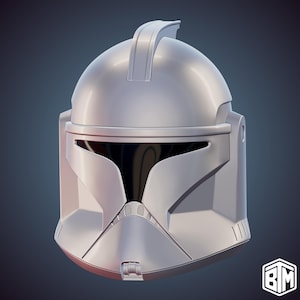 May include: A silver-colored, detailed helmet with a distinctive visor and a raised ridge on top. The helmet has a smooth, metallic finish and is likely a replica or a prop from a science fiction or fantasy theme.
