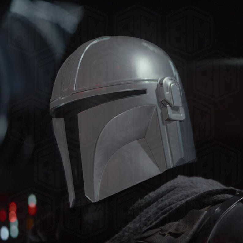 May include: A close-up of a silver Mandalorian helmet. The helmet has a T-shaped visor and a rounded top. The helmet is made of a metallic material and has a matte finish. The helmet is part of a costume.