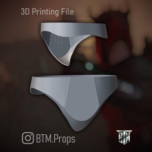 May include: Two gray 3D-printed objects, possibly parts of a costume or prop, are displayed against a blurred background. The text "3D Printing File" is at the top. The lower object is a complete form, while the upper one is a partial view.