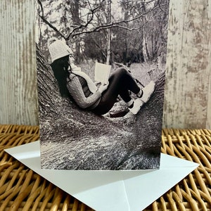 Linda garota relaxando lendo um livro em uma árvore na fotografia preto e branco da floresta