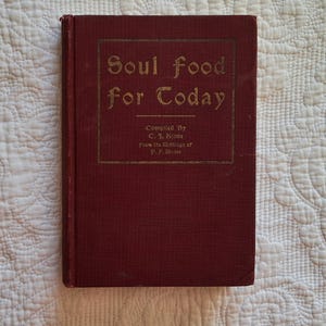 May include: A red hardcover book titled "Soul food for Today" with gold lettering. The book was compiled by C. J. Kiane from the writings of P. F. Bruce.