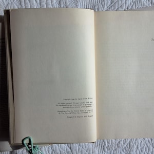 May include: Open book with aged, off-white pages. The text "GUMP'S TREASURE A Story of San Francisco" is visible on a detached page. The book is held open with a light green paper clip. Copyright information is printed on the right page.