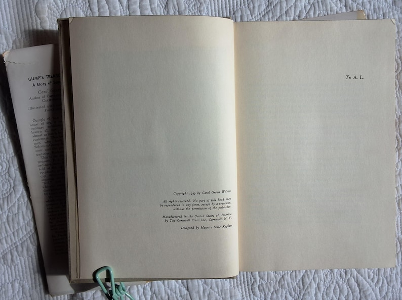 May include: Open book with aged, off-white pages. The text "GUMP'S TREASURE A Story of San Francisco" is visible on a detached page. The book is held open with a light green paper clip. Copyright information is printed on the right page.