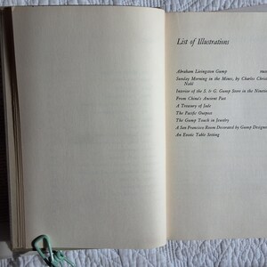 May include: Open book with the title "GUMPS" visible on the left page. The right page displays a "List of Illustrations" with titles and page numbers. A light green paper clip holds the pages together. The book is on a white surface.