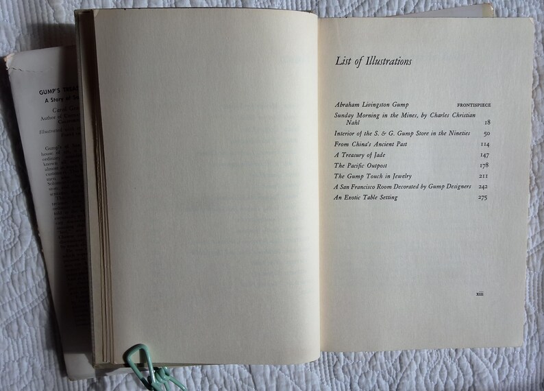 May include: Open book with the title "GUMPS" visible on the left page. The right page displays a "List of Illustrations" with titles and page numbers. A light green paper clip holds the pages together. The book is on a white surface.