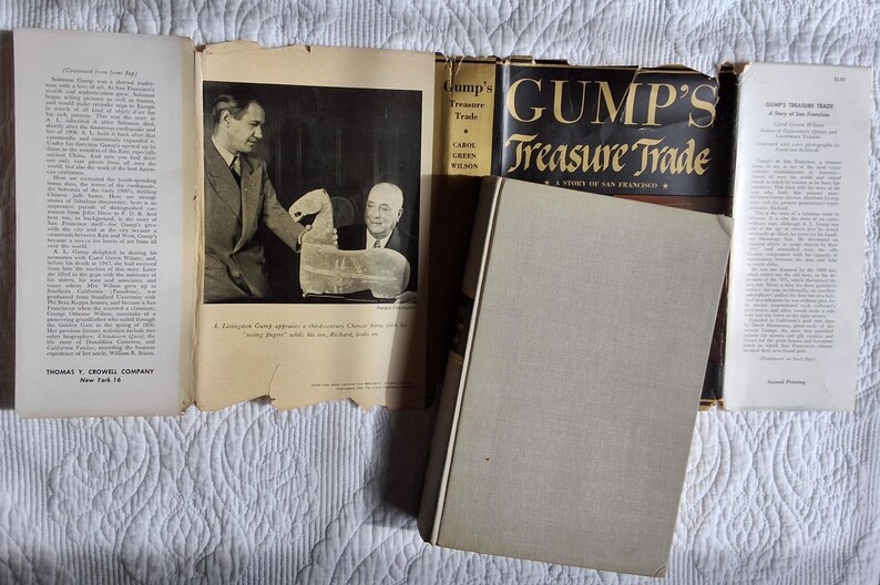 May include: An open book and several pamphlets are displayed with a hardcover book titled "Gump's Treasure Trade." The book's cover is black with gold lettering. The pages show text and a black and white photo.