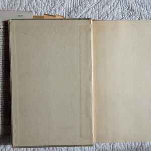 May include: An open vintage book with aged, cream-colored pages. The left side shows the text of the book, while the right side is blank. The book's cover is visible, with the title "Gump's Treasure" and author information.