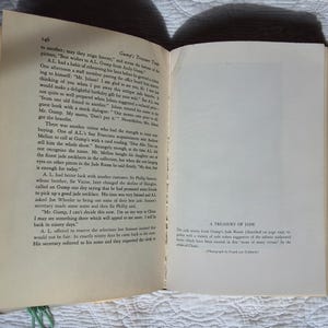 May include: Open book with text on the left page and a blank page with text at the bottom on the right. The text on the right page reads "A Treasury of Jade". The book is open on a white surface.