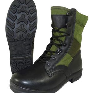 Könnte beinhalten: Schwarze Lederstiefel mit grünen Canvas-Einsätzen und Schnürsenkeln. Die Stiefel haben eine robuste Sohle.