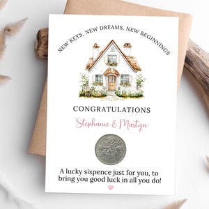 Może przedstawiać: Biała kartka z ilustracją domu i tekstem "NEW KEYS, NEW DREAMS, NEW BEGINNINGS" oraz "CONGRATULATIONS Stephanie & Martyn". Moneta sześciopensowa znajduje się pod tekstem, z wiadomością "A lucky sixpence just for you, to bring you good luck in all you do!"