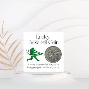 Może przedstawiać: Biała karta z zielonym tekstem, który brzmi "Lucky Baseball Coin". Zielona sylwetka baseballisty trzyma kij. Na karcie znajduje się srebrna moneta sześciopencowa. Tekst pod monetą brzmi "A lucky sixpence just for you to bring you good luck in all you do."