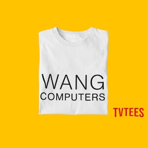 May include: White t-shirt with black text that reads "WANG COMPUTERS" on a yellow background. The text "TVTEES" is in red at the bottom right corner of the image.