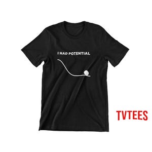 Könnte beinhalten: Ein schwarzes Kurzarm-T-Shirt mit einer weißen Grafik einer geschwungenen Linie, die in einem kleinen Kreis endet, begleitet von dem weißen Text "I HAD POTENTIAL" über der Grafik. Das T-Shirt hat einen Rundhalsausschnitt und eine Standardpassform.
