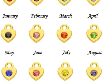 May include: Gold-colored heart-shaped pendants, each with a different colored gemstone. The months of the year are written below each pendant. The gemstones are red, pink, blue, clear, black, pink, orange, green, blue, pink, yellow, and purple.
